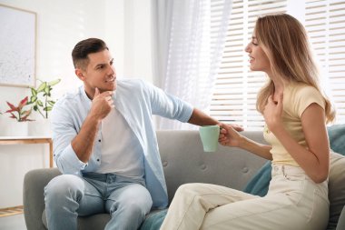 Man and woman talking in living room clipart