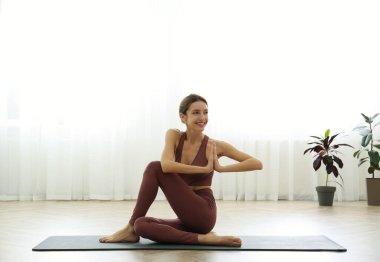 Genç bir kadın yoga stüdyosunda balık lordu olarak çalışıyor. Ardha Matsyendrasana pozu