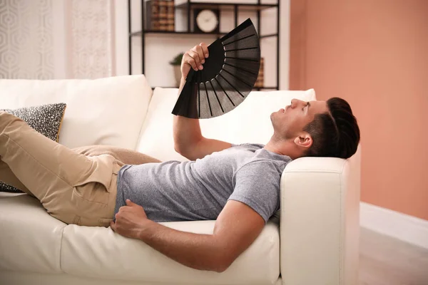 Uomo Con Ventilatore Mano Sdraiato Sul Divano Stagione Estiva — Foto Stock