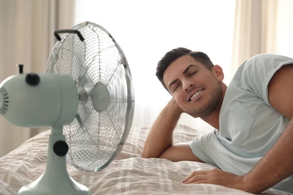 Man Geniet Van Luchtstroom Van Ventilator Bed Kamer Zomer Warmte — Stockfoto
