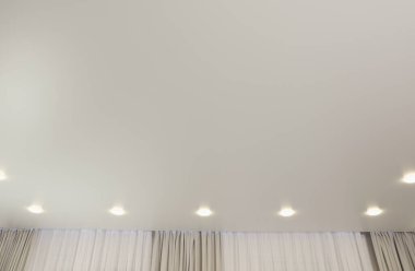 Beyaz tavan, içeride lambalar var.