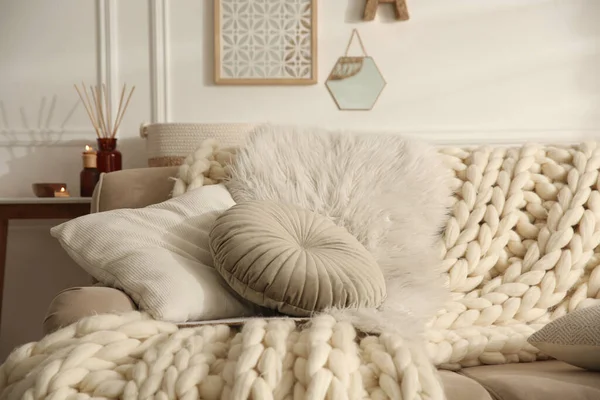 編んだ毛布とクッションが部屋にあるベージュのソファ インテリアデザイン — ストック写真