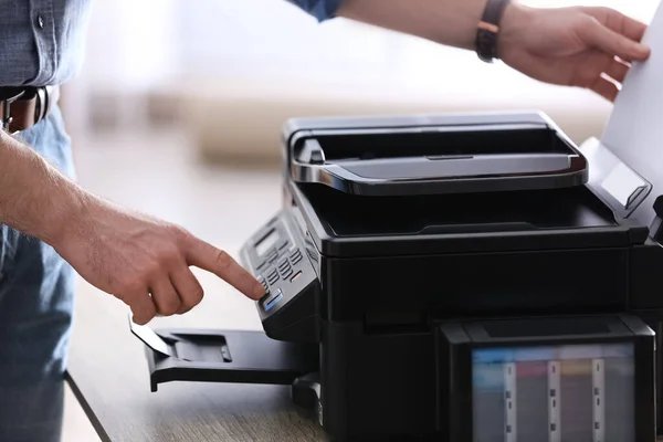 Employee using modern printer in office, closeup