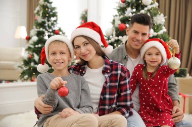 Mutlu bir aile ve Noel ağacının yanında sevimli çocuklar.