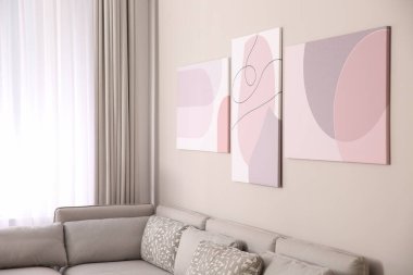 Büyük rahat kanepe ve resimlerle dolu şık bir oturma odası.