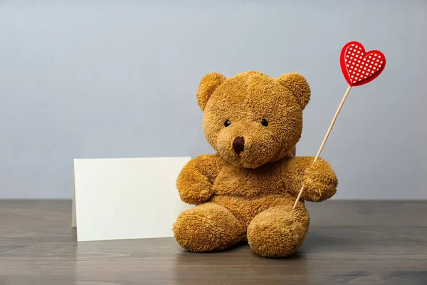 Niedlicher Teddybär Mit Rotem Herz Und Leerer Karte Auf Holztisch — Stockfoto