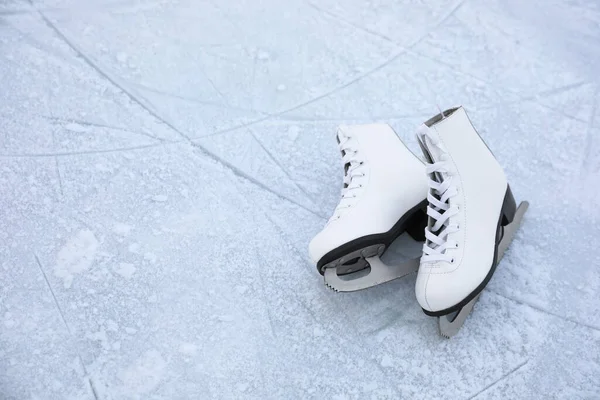 Figure skates with laces on ice, space for text. Winter outdoor activities