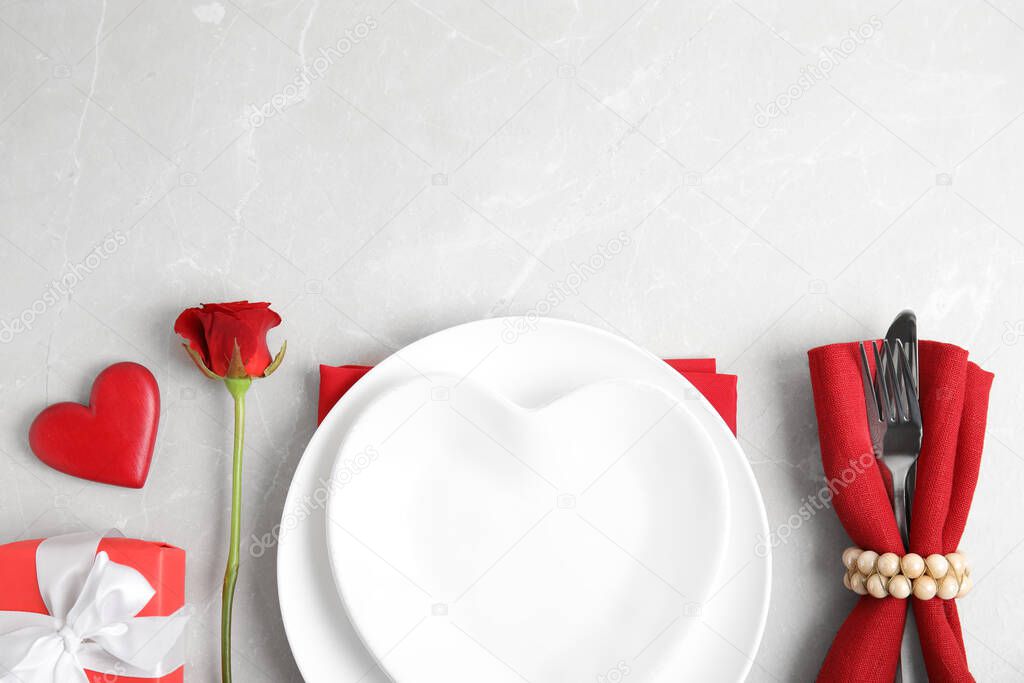 Romantic table setting on light grey background, flat lay with space for text. Valentine's day celebration