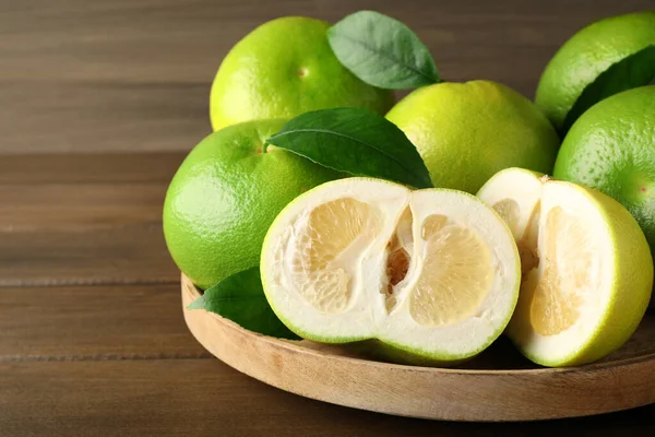 stock image Whole and cut sweetie fruits on wooden table