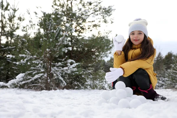 可爱的小女孩在冬天的森林里打滚雪球 — 图库照片