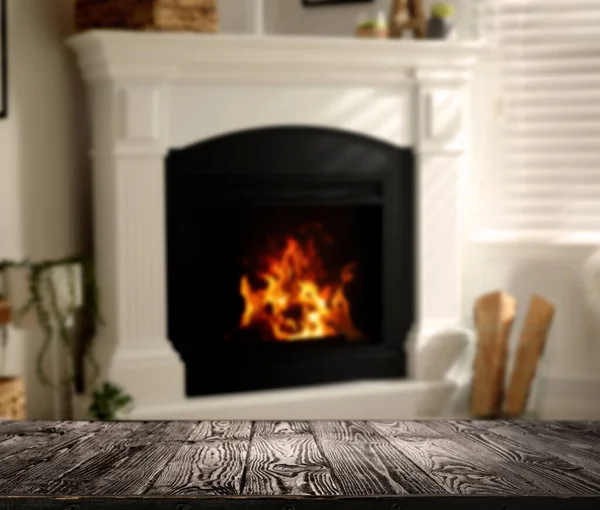 空の木製の表面と部屋の暖炉のぼやけた景色 — ストック写真