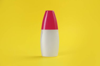 Sarı zemin üzerinde böcek kovucu sprey olan şişe.