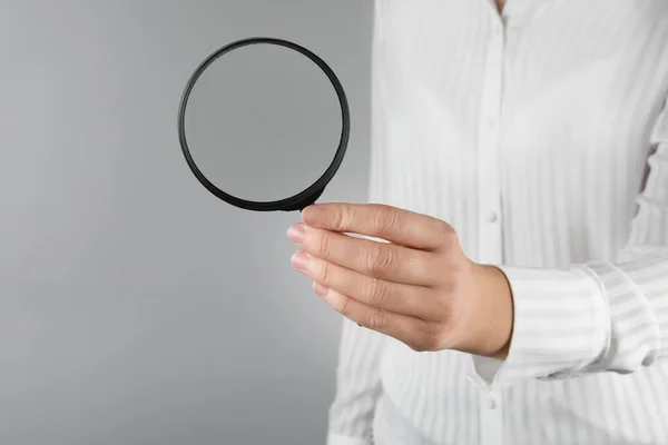 Mujer Sosteniendo Lupa Sobre Fondo Gris Primer Plano Buscar Concepto —  Fotos de Stock