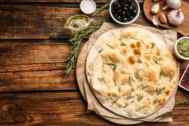 Düz kompozisyon ve Focaccia ekmeği ahşap masada. Metin için boşluk