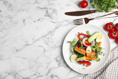 Beyaz mermer masada taze organik mikroyeşil tabakta salata, düz. Metin için boşluk