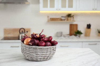 Modern mutfağın beyaz mermer masasında taze soğanlı sepet. Metin için boşluk