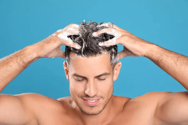 Bonito Homem Lavar Cabelo Fundo Azul Claro — Fotografia de Stock