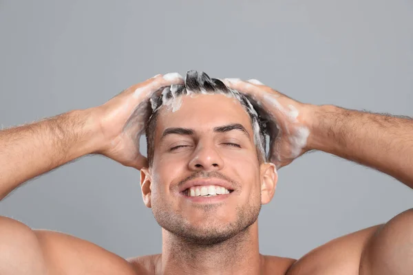 Bonito Homem Lavando Cabelo Fundo Cinza — Fotografia de Stock