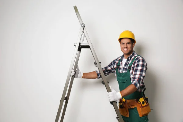 Professionele Bouwer Met Metalen Ladder Lichte Ondergrond — Stockfoto