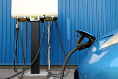 Dışarıdaki istasyondan modern elektrikli araba şarj ediliyor.