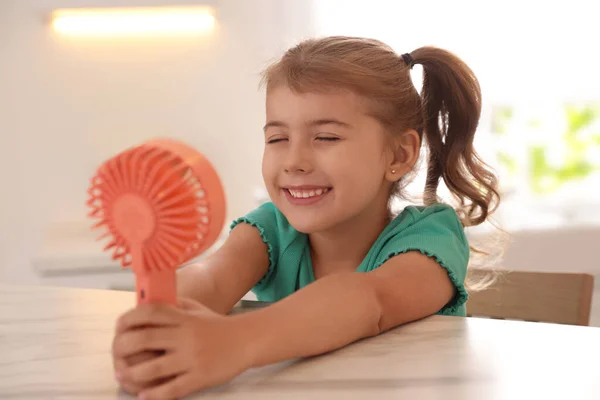 Klein Meisje Geniet Van Luchtstroom Van Draagbare Ventilator Aan Tafel — Stockfoto