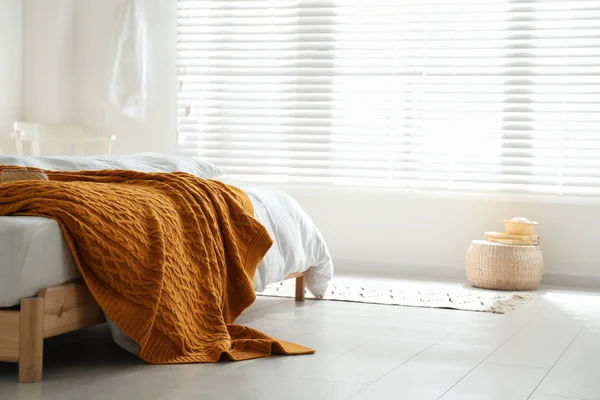 スタイリッシュな部屋のインテリアで再生暖かいニットと快適なベッド — ストック写真
