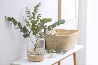 Odadaki masada taze okaliptüs dalları olan vazo. İç tasarım