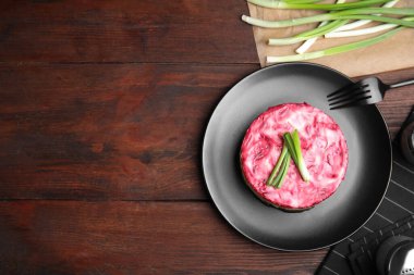 Kürk manto altında ringa, ahşap masada servis edilir, düz yerde yazı için yer vardır. Geleneksel Rus salatası