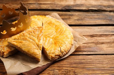 Geleneksel galette des Rois ve tahta masa üzerinde kağıt taç.