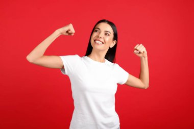 Güçlü kadın, kırmızı arka plandaki kız gücünün sembolü. 8 Mart konsepti