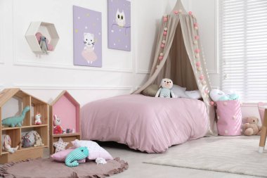 Oyuncak ve modern mobilyalarla dolu şirin bir çocuk odası.