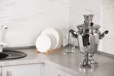 Mutfaktaki gri tezgahta metal semaver. Rus çay kültürü