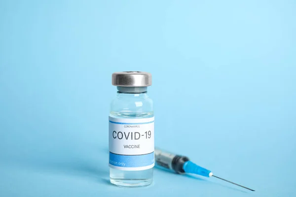 Açık Mavi Zemin Üzerinde Koronavirüs Aşısı Şırınga Olan Şişe — Stok fotoğraf