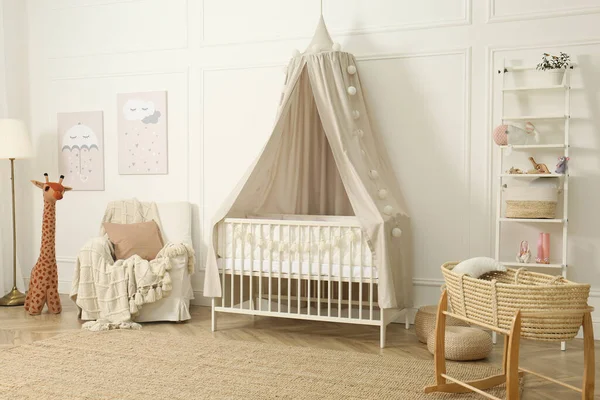 Elegante interior de la habitación del bebé recién nacido con cama colgando  con dosel blanco con cuna