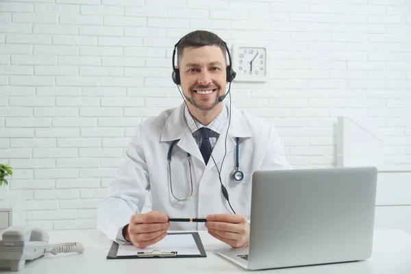 Doutor Com Fone Ouvido Sentado Mesa Clínica Linha Directa Dos — Fotografia de Stock