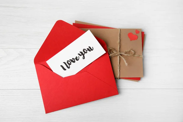 白い木製の背景に封筒の愛の手紙とスタック フラットレイアウト — ストック写真