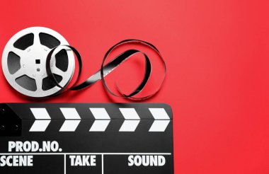 Kırmızı arkaplanda el ve makara, metin için yeri olan düz bir yer. Video üretim ekipmanları