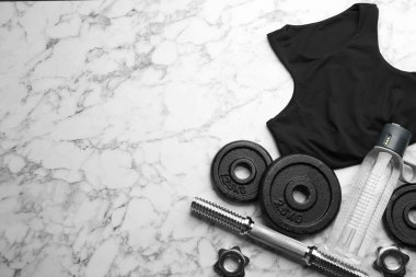 Spor kıyafetleri ve ekipmanlarla bembeyaz mermer masa üzerinde düz kompozisyon, yazı için boşluk. Jimnastik