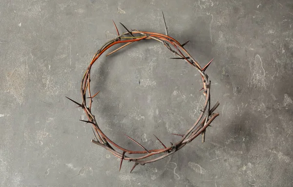 Crown of thorns on grey background, top view. Easter attribute