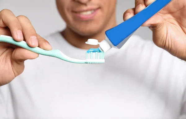 Man Applying Toothpaste Brush Light Background Closeup — Stock Photo, Image