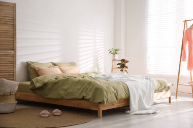 Şık oda içinde yumuşak battaniyeli büyük bir yatak.