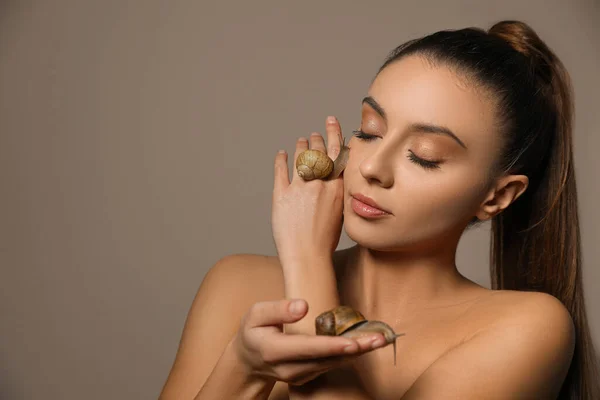 Mulher Bonita Com Caracóis Suas Mãos Contra Fundo Bege Espaço — Fotografia de Stock