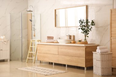 Modern banyo içinde şık bir ayna ve kap lavabosu var.