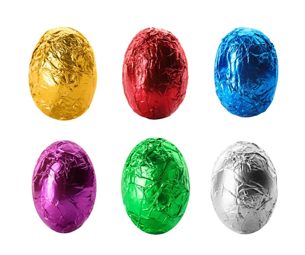 Beyaz arka planda parlak folyoya sarılı çikolatalı yumurtalar. 