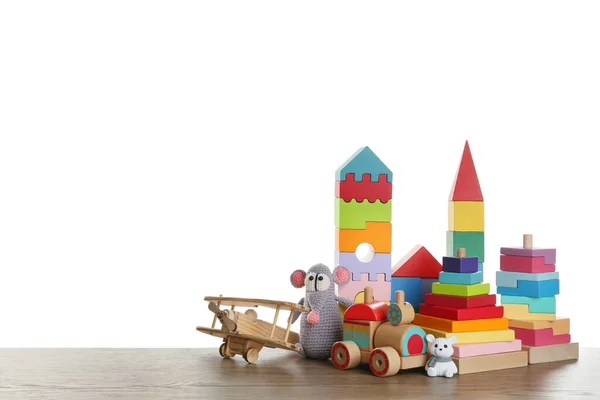 一套不同的玩具放在木制桌子上 衬托着白色背景 案文的篇幅 — 图库照片