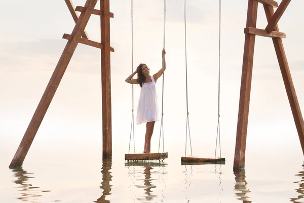 Молодая Женщина Наслаждается Восходом Солнца Качелях Над Водой — стоковое фото