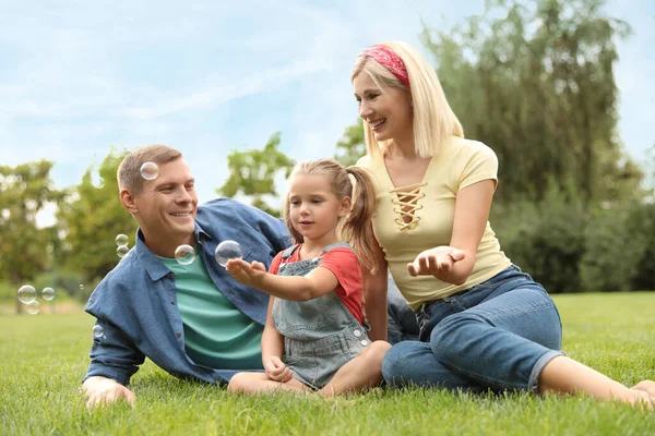 Feliz Família Soprando Bolhas Sabão Parque Grama Verde — Fotografia de Stock