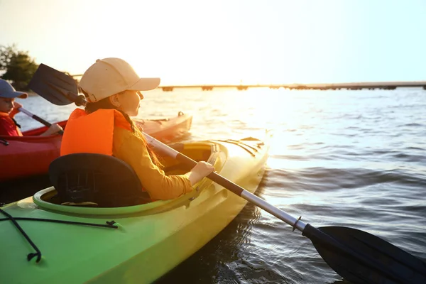 Little children kayaking on river. Summer camp activity