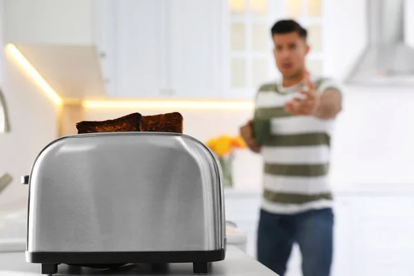 情绪化的男人在厨房准备早餐 专注于烤面包片烤面包机 — 图库照片