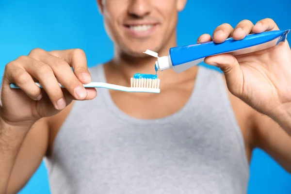 Man Applying Toothpaste Brush Blue Background Closeup — Stock Photo, Image